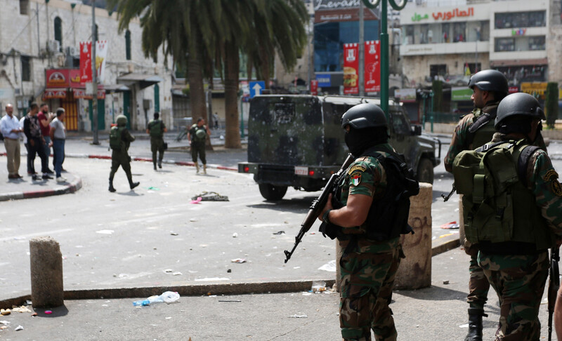 Palestinian Authority forces standing guard with a jeep