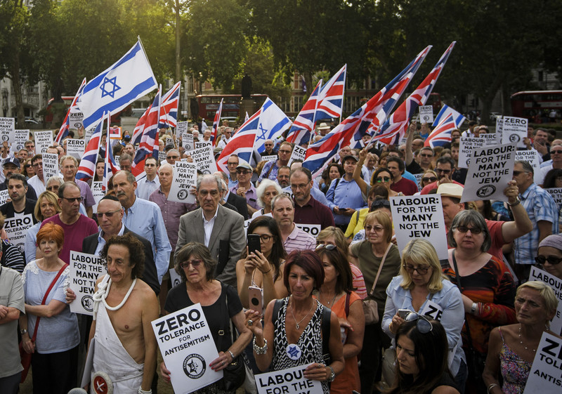 A crown of demonstrators raises British and Israeli flags
