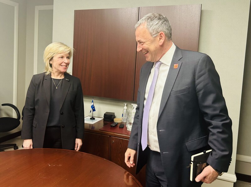 A woman and man stand next to a table and smile at eachother