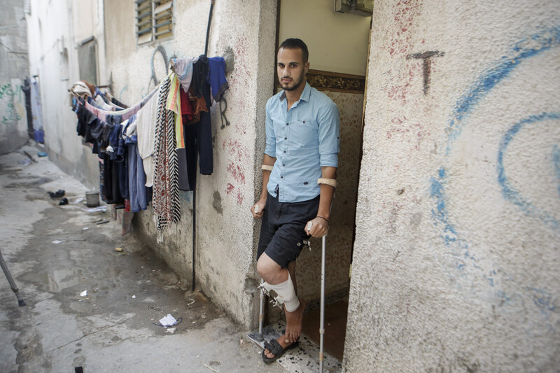 A man with crutches stands in a doorway