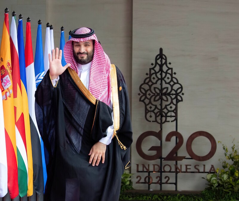 Saudi Crown Prince Mohammad bin Salman waves alongside a line of flags