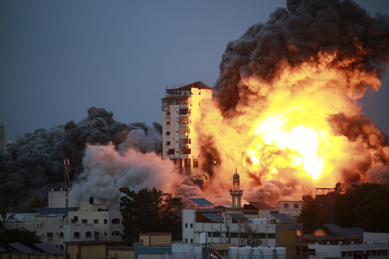 A fireball explodes next to a residential tower against a dark sky