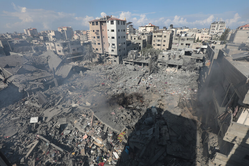 Aerial view of bombed out area where a large building once stood in densely populated area