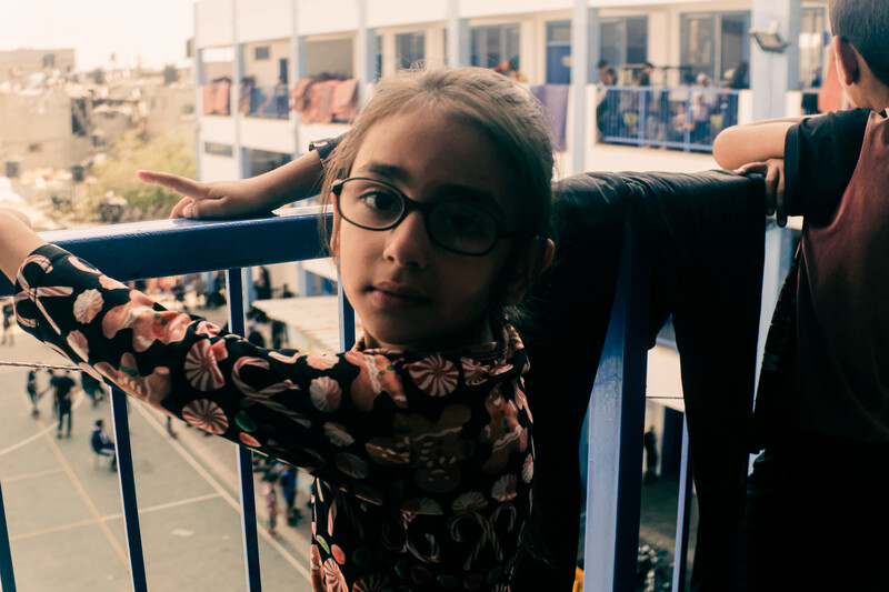 A girl stands on a balcony looking back