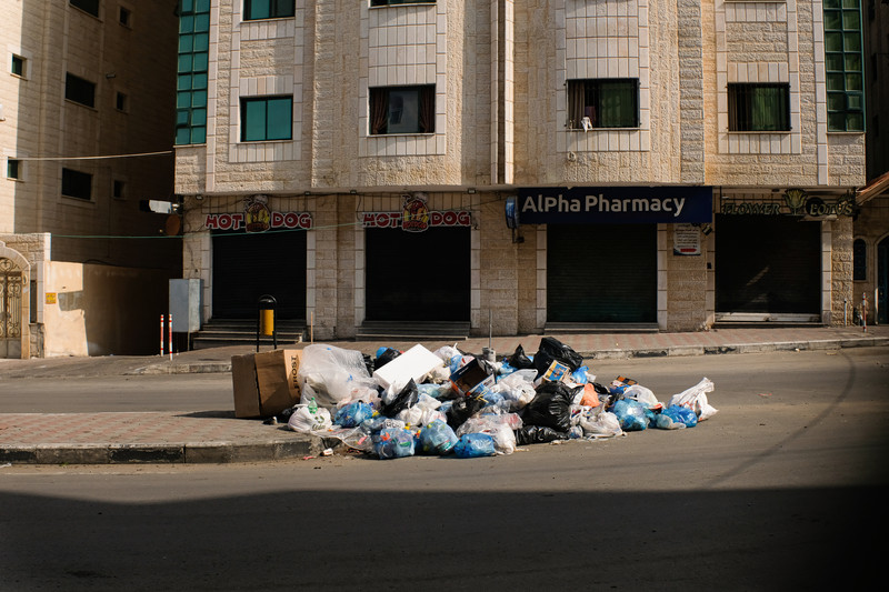 A heap of garbage lies in an empty street