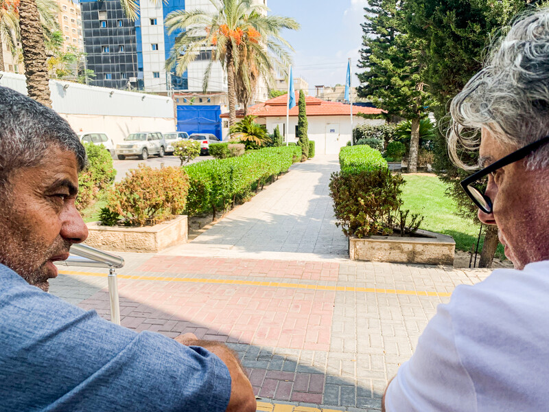 Two men, in a manicured backyard, talking