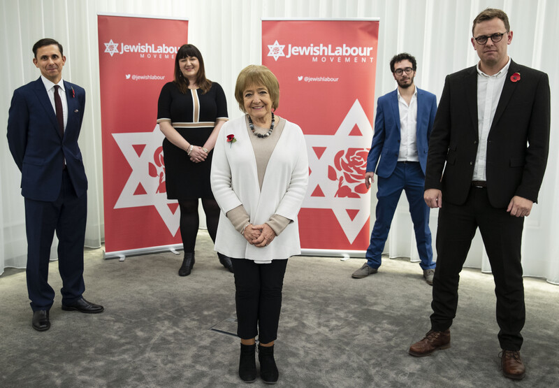 Five people standing in front of Jewish Labour Movement banners