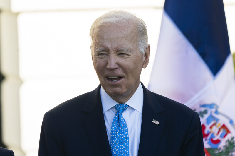 President Joe Biden with a flag behind him