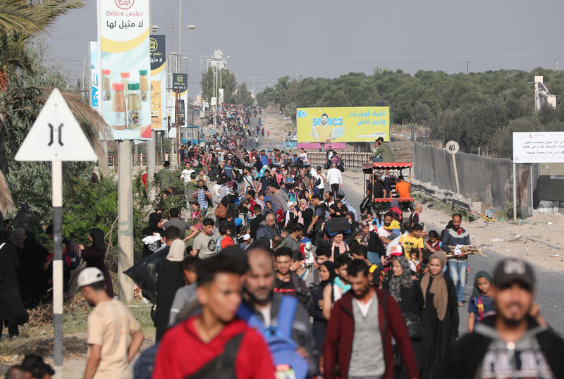 Landscape view of hundreds of people walking in a long line stretching back to the horizon