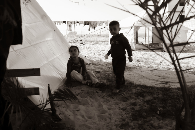 Two children play by a tent.