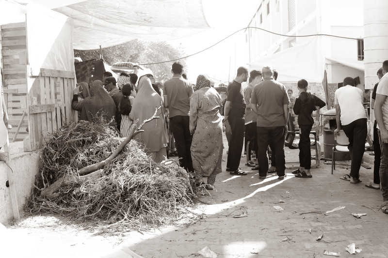 People line up by a makeshift bakery
