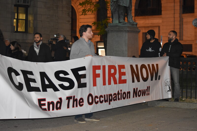 People stand with a banner calling for a ceasefire