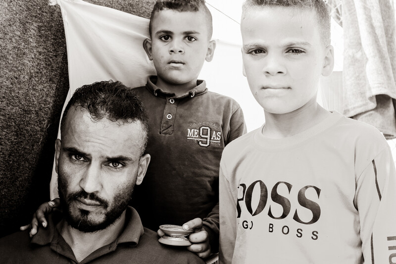 A man poses with two boys