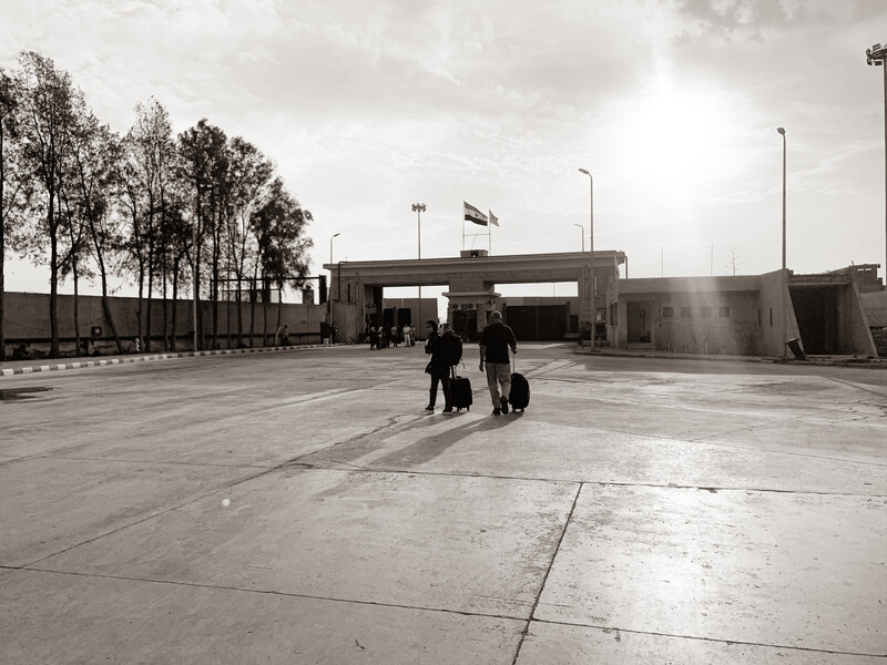 Two people walk across an empty courtyard