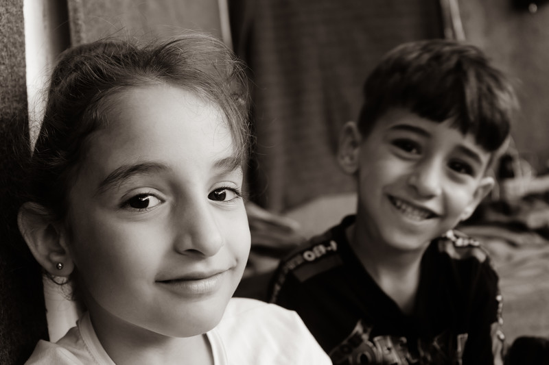 Two children smile at the camera