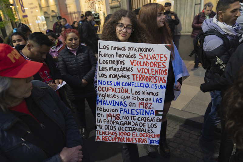 A woman holds a sign with writing in Spanish