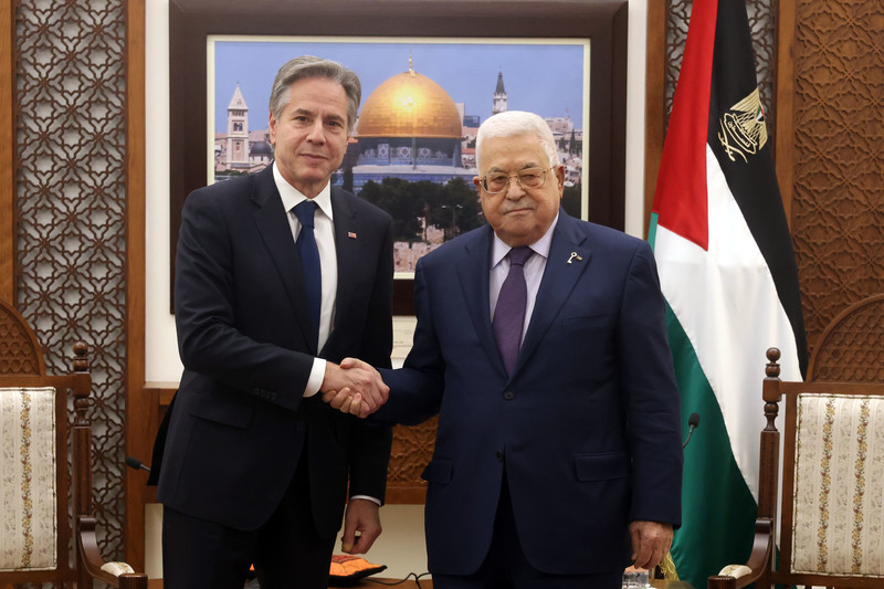Blinken and Abbas shake hands in front of a framed picture of Jerusalem's Dome of the Rock
