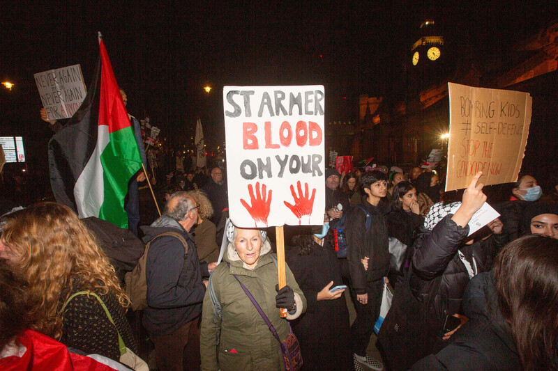 Woman with placard reading: Starmer blood on your hands