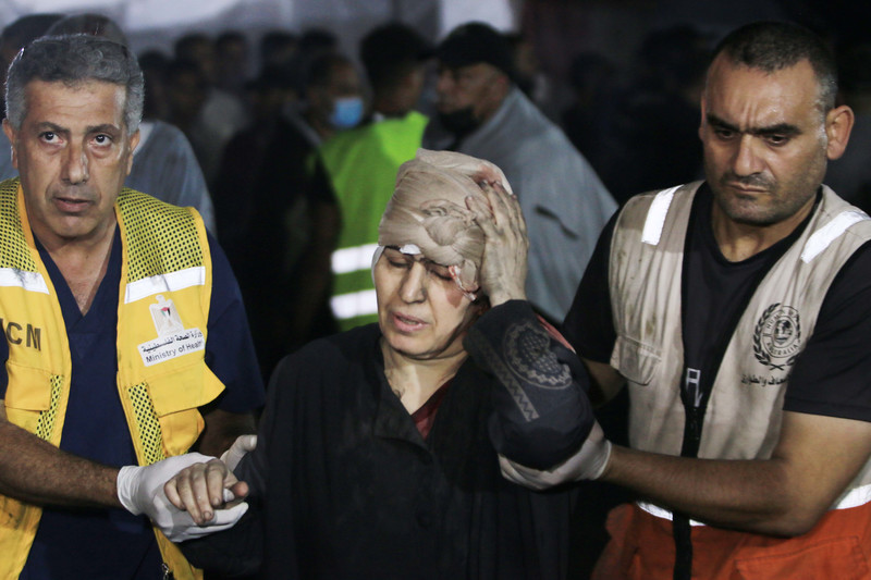 A woman in distress is guided by two emergency workers