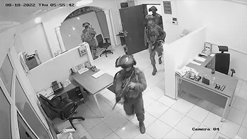 Black and white still of armed soldiers in an office aBlack and white still of armed soldiers in an office