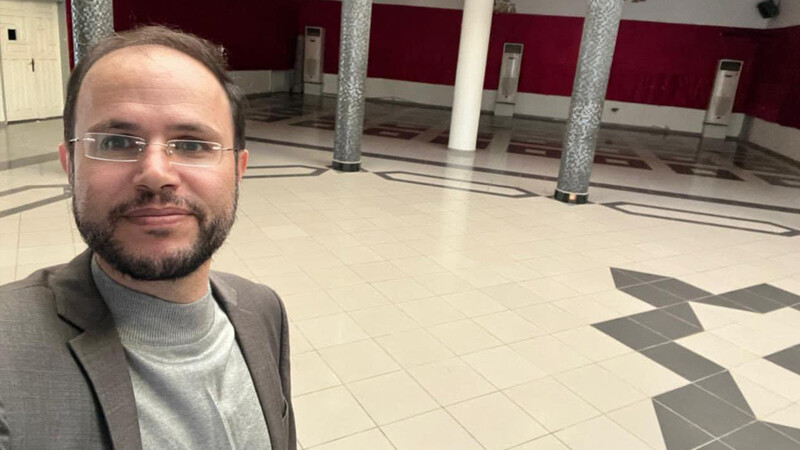 A man takes a selfie in an empty hall