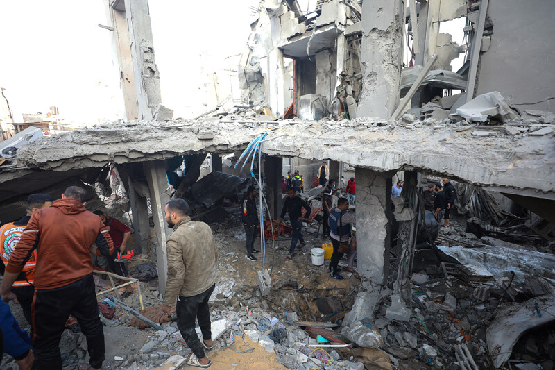 A man walks past a house destroyed in a missile attack