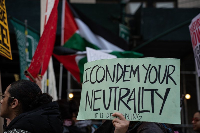A protest sign reads: I condemn you neutrality
