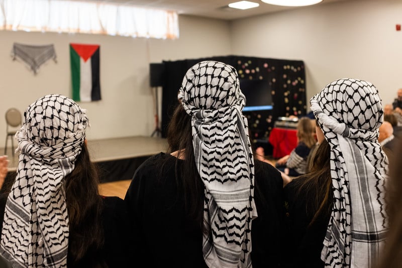 People wearing the Palestinian kefiyeh at an event