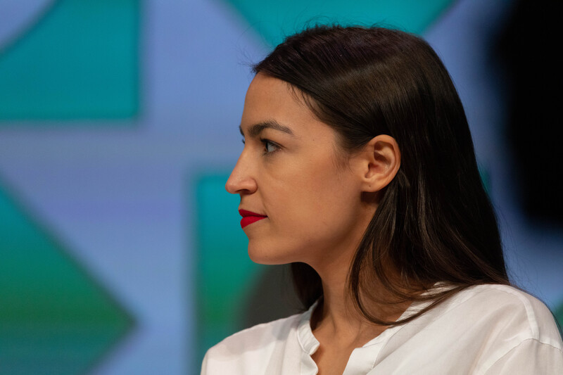 Side profile of a woman with long black hair and a white shirt 