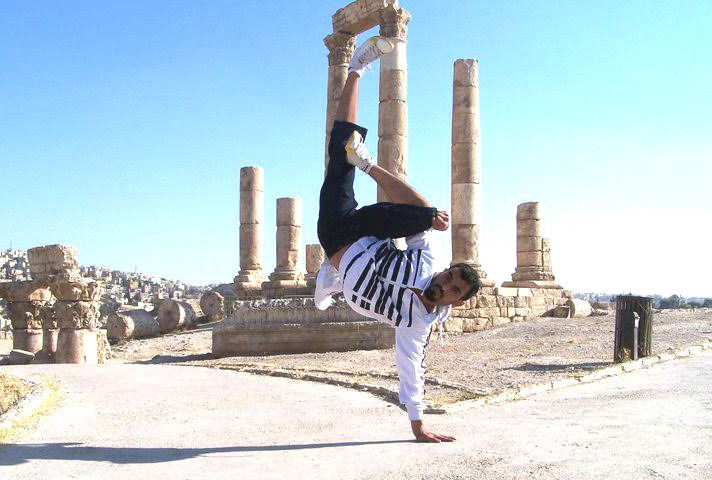 A man dances in front of ancient ruins 