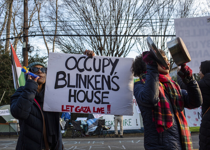 Protestors hold a sign reading: Occupy Blinken's house