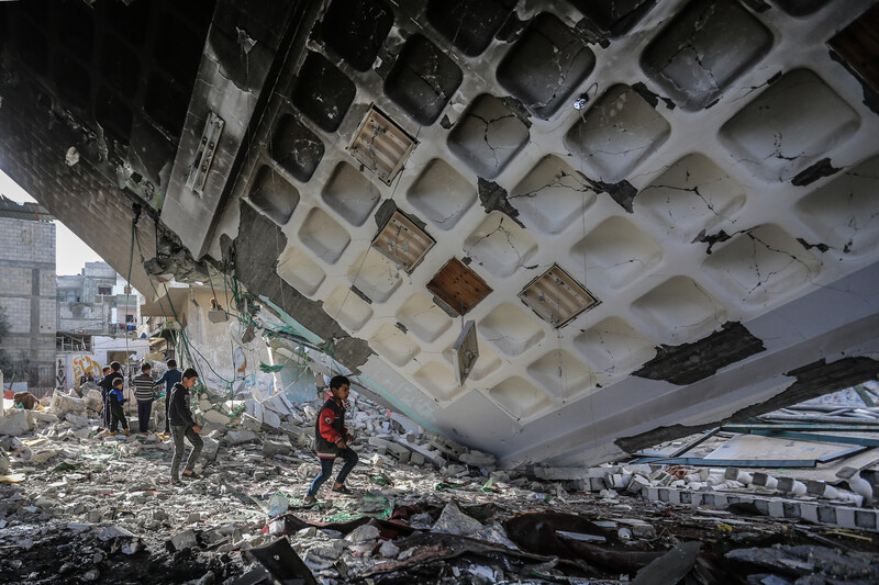 children walk in rubble