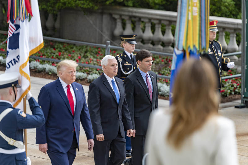 Secretary of Defense Mark Esper walks alongside Vice President Mike Pence and President Donald Trump with military personnel present at Arlington National Cemetery