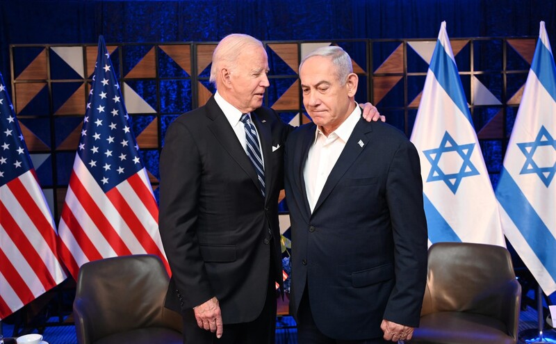 President Joe Biden puts his arm around Prime Minister Benjamin Netanyahu with American and Israeli flags behind them