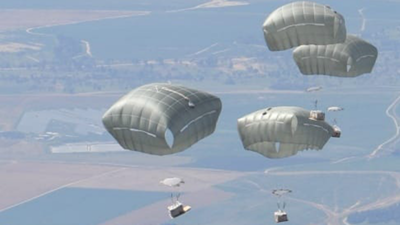 Aerial image of parachutes descending onto land 