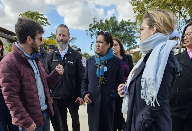 A group of people talk outdoors