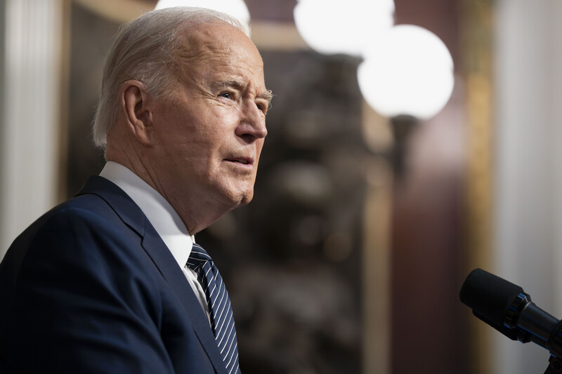 Joe Biden at a microphone with three lights above him