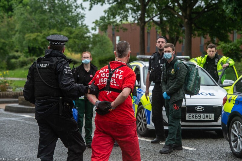 Police lead a man away in handcuffs