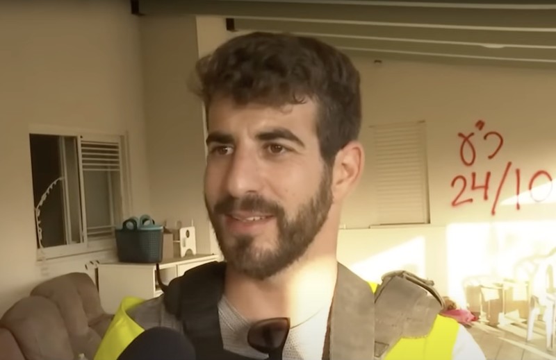 A man with a high-vis vest speaks to camera