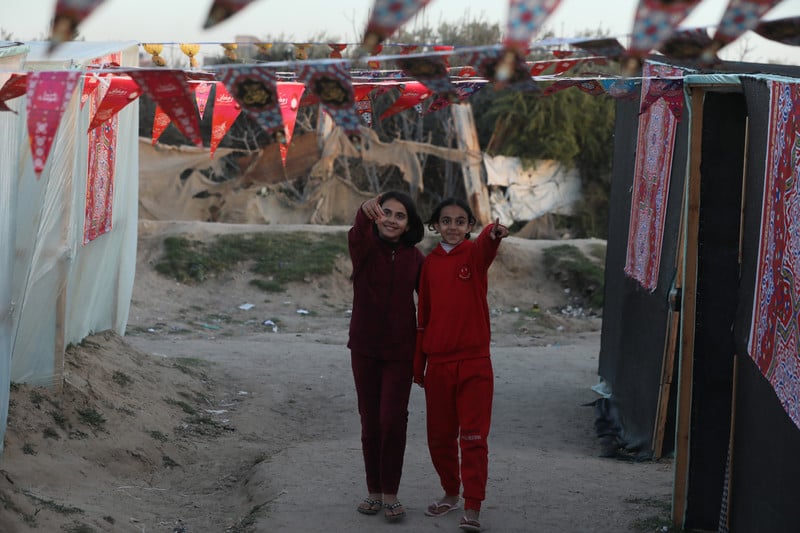 two girls walk between decorated tents