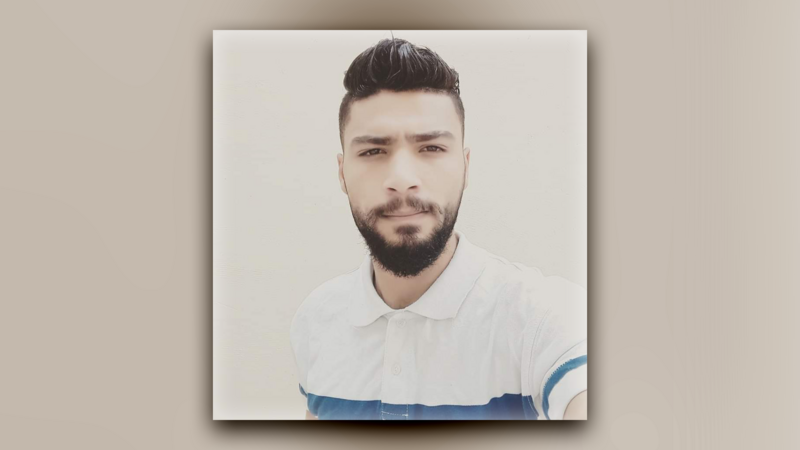 A portrait of a young man wearing a white short sleeved shirt