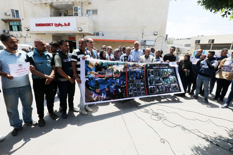 Journalists hold up a banner depicting their slain colleagues
