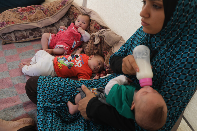 A mother feeds her baby milk