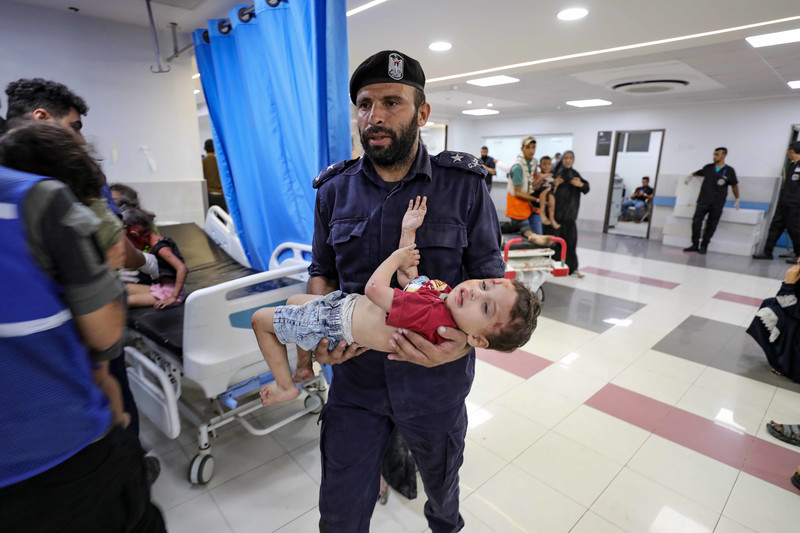 An emergency worker carries wounded child