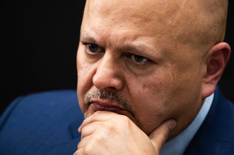 Close-up portrait of Karim Khan with hand on chin