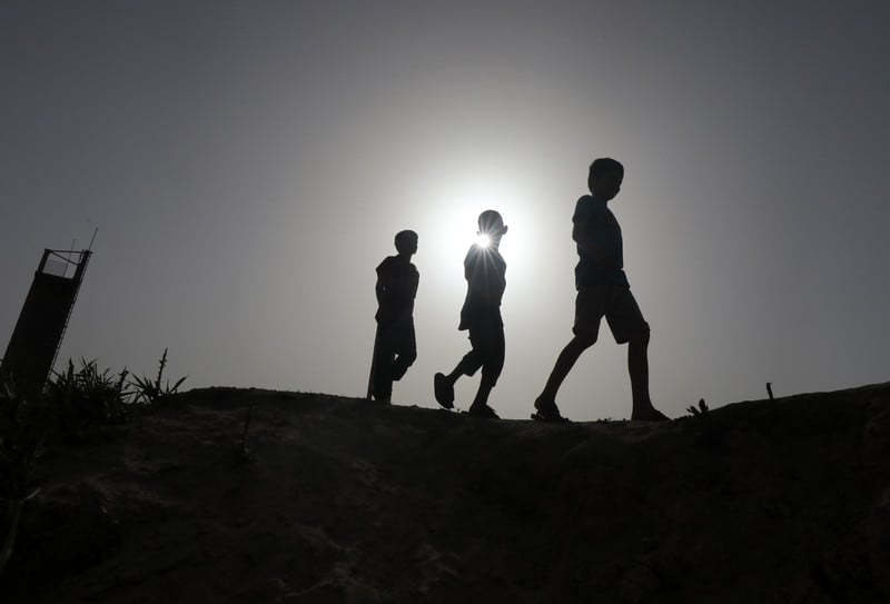 Three Palestinians walking as hundreds of thousands flee Rafah in southern Gaza