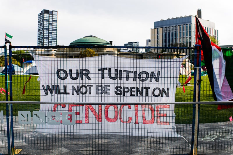 A sing reads: Our tuition will be spent on genocide 