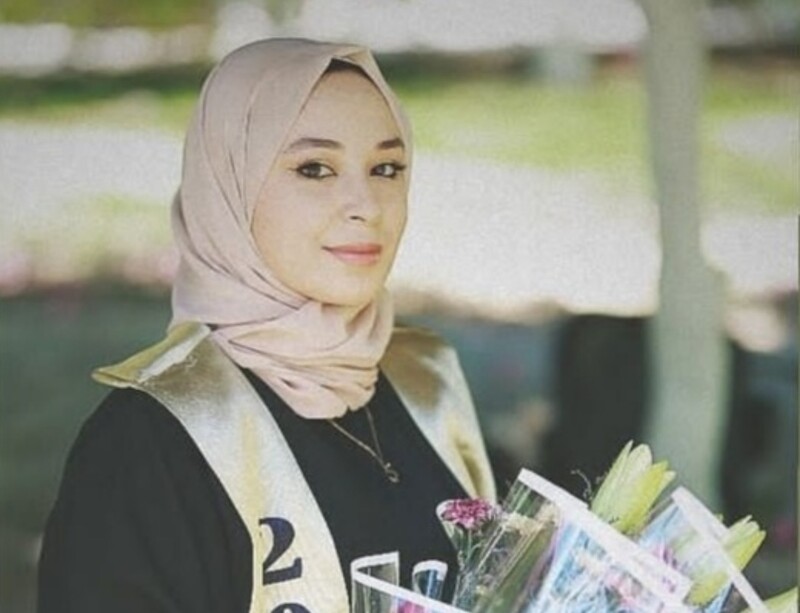 A young woman smiles at the camera