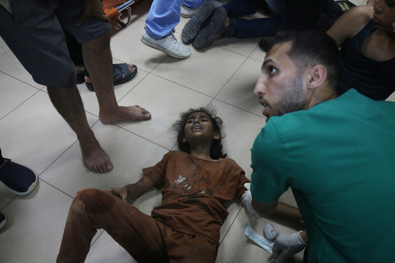 An injured child screams in pain on the floor of a hospital