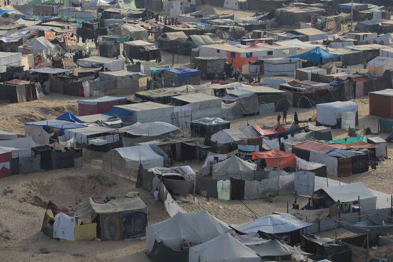 Dozens of tents fill a sandy space